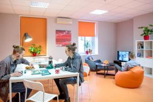 a group of people sitting at a table in a waiting room at Liberty in Rīga