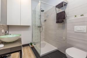 een badkamer met een douche, een toilet en een wastafel bij Kappa apartments in Rijeka