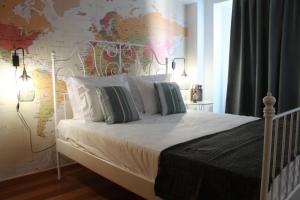 een slaapkamer met een wit bed en een kaart aan de muur bij Travellers Pearl by Storytellers in Funchal