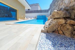 una casa con piscina e muro di pietra di Villa del Dragone a Tricase