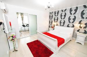 - une chambre avec un lit blanc et un tapis rouge dans l'établissement Jazz Studio, à Galaţi