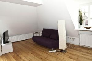 a living room with a couch and a television at Altstadt-Domizil 6 in Leer