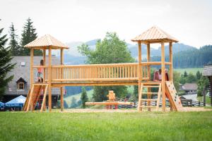 einen Spielplatz mit Holzspielstruktur im Gras in der Unterkunft Gasthof Unterberger in Sankt Kathrein am Offenegg