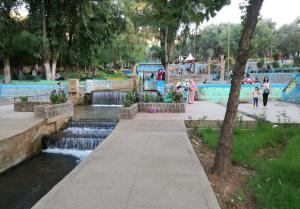 een park met een waterpark met een waterval bij Hotel Imilchil in Zaouia ech Cheïkh