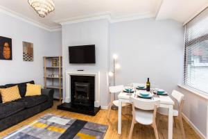 a living room with a table and a fireplace at Northwood Park View in Stoke on Trent