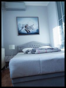 a bed in a bedroom with a picture on the wall at Apartment Arena Silver in Belgrade