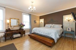 1 dormitorio con cama, escritorio y espejo en Charles Street Vacation Home, en Lethbridge