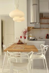 a kitchen with a wooden table and white chairs at Pinehouse King Suite in Nikiti