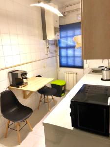 eine Küche mit zwei Stühlen und einem Tisch darin in der Unterkunft Alójate en Vigo! Casita bien equipada in Vigo