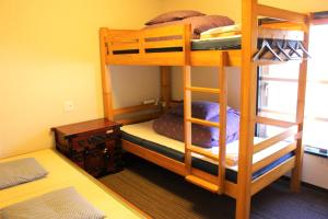 two bunk beds in a small room with a table at K's House Tokyo Oasis - Asakusa Downtown in Tokyo