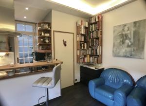 ヌイイ・シュル・セーヌにあるcosy rare 2 bedroom apartment around a private gardenのリビングルーム(青いソファ、椅子付)