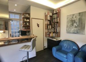 sala de estar con sofá azul y silla en cosy rare 2 bedroom apartment around a private garden, en Neuilly-sur-Seine