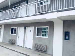 a building with two white doors and a balcony at Value Inn in Sylmar