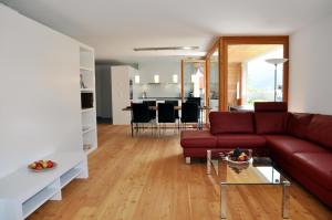 a living room with a red couch and a table at Crastuoglia 720 - Nr. 1 in Scuol