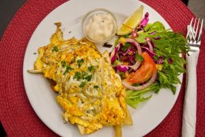 a plate of food with o mexican food and a salad at Railway Hotel/Motel Hokitika in Hokitika