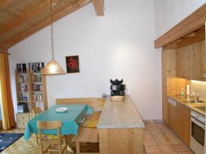 a kitchen with a blue table in a room at Pütvia E6 in Scuol