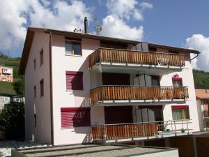 un edificio con balcones de madera en un lateral en Pütvia E6 en Scuol