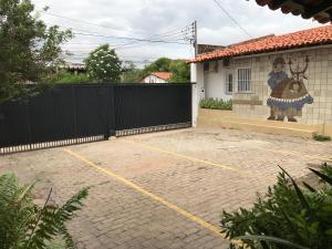 a parking lot in front of a house with a fence at Hotel Velho Monge in Teresina