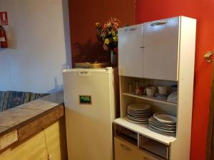 a refrigerator in a kitchen with plates on a shelf at Hospedaje Casa Máncora in Máncora