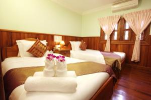 a hotel room with two beds with towels at Hima Boutique in Siem Reap