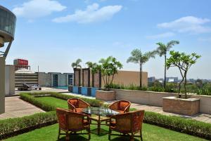 a patio with a table and chairs on a roof at Savoy Suites Manesar in Gurgaon