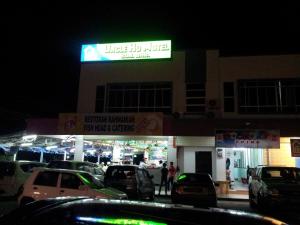 a building with cars parked in a parking lot at night at Uncle Ho Motel in Papar