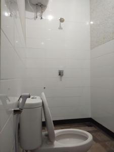 a white bathroom with a toilet in a room at Tirta Yoga Inn in Padangbai