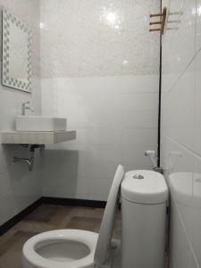 Baño blanco con aseo y lavamanos en Tirta Yoga Inn, en Padangbai