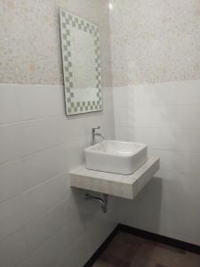 baño con lavabo y espejo en la pared en Tirta Yoga Inn, en Padangbai