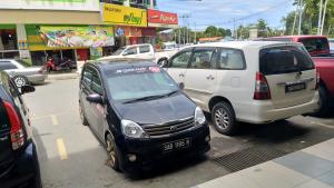a couple of cars parked in a parking lot at Uncle Ho Motel in Papar
