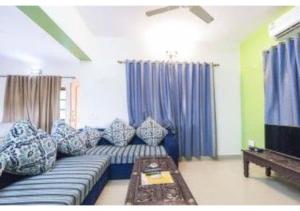 a living room with a blue couch and a tv at 4Bhk Exotic Villa with Swimming pool in Arpora