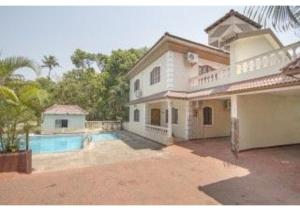 a large white house with a swimming pool at 4Bhk Exotic Villa with Swimming pool in Arpora