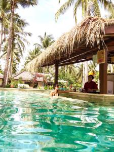 a man and a child in the swimming pool at a resort at Trawangan Oasis in Gili Trawangan