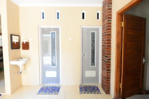un bagno con due porte e un lavandino di nDalem Eyang Dwijo a Yogyakarta Altre 20 foto