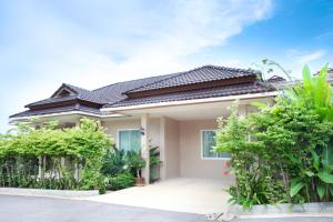 a house with a lot of plants in front of it at Villa with private pool in Hua Hin
