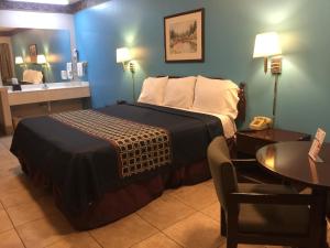 A bed or beds in a room at Texas Inn and Suites City Center at University Dr.