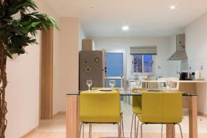 a kitchen with a dining table with yellow chairs at Eden Beach Apartment 207 in Limassol