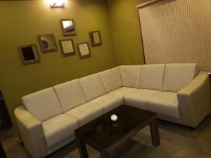 a living room with a white couch and a table at Belen - Service Apartment in Mangalore