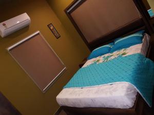 a bedroom with a bed with a head board at Belen - Service Apartment in Mangalore