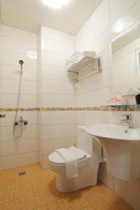 台東市的住宿－輕旅村-陽光輕旅（電梯民宿），白色的浴室设有卫生间和水槽。