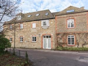 a large brick building with white doors and windows at The Leat at Wynyard Mill in Malmesbury