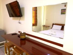 a mirror in a room with a table and a bed at Khong Chiam 2 Hotel in Khong Chiam