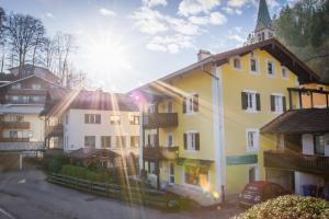 een geel en wit gebouw met een kerk bij Ferienwohnung Marianne Ortszentrum für Familien 180qm in Berchtesgaden