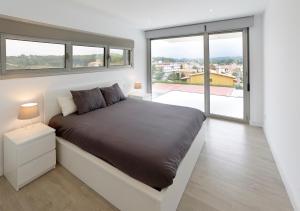 a bedroom with a bed with a large window at La casa de Marta in Celorio