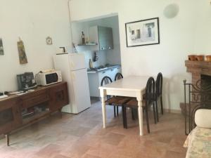 eine Küche mit einem weißen Tisch und einem weißen Kühlschrank in der Unterkunft Masseria Gargaleo in Nova Siri