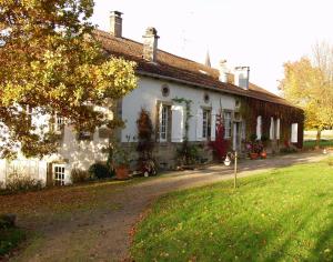 a white house with a yard in front of it at Le Prieuré in Aydoilles