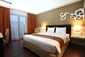 a bedroom with a large bed in a hotel room at Soll Marina Hotel & Conference Center Bangka in Pangkal Pinang
