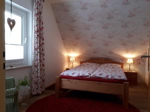 a bedroom with a bed with a red rug and a window at Ferienhaus Julius in Willingen