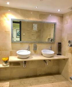 a bathroom with two sinks and a mirror at Hotel Calasanz in Molins de Rei