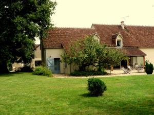 a house with a green yard in front of it at La Maison de Philomène in Le Grand Entrevin